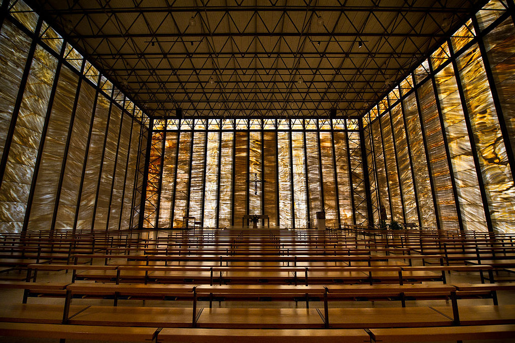 Interior view of the church toward the altar. The lightly built, minimalist, spartan benches appear airy, thus neither obstructing the view of the room in its entirety nor distracting the viewer.