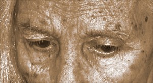 Sepia-toned black & white photographic close-up of a woman's forehead and eyes.